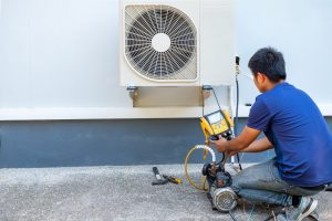 male-technician-installing-outdoor-unit-air-conditioner-cool-household-summer-air-compressor-electronic-hot-summer-high-temperature-tropical-countries-scaled