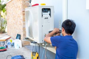 male-technician-installing-outdoor-unit-air-conditioner-cool-household-summer-air-compressor-electronic-scaled