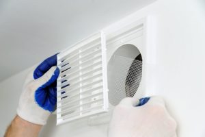 worker-installs-ventilation-grille-scaled